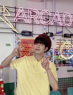 a young man standing in front of a neon sign