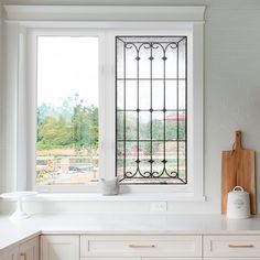 a kitchen with white cabinets and an iron window