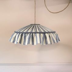 a blue and white striped lamp hanging from a ceiling