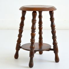 a small wooden stool sitting on top of a white floor