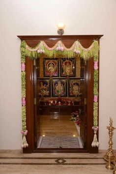 an entrance to a temple decorated with flowers and garlands on the door, along with other decorations