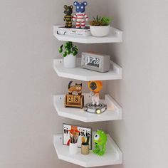 three white shelves in the corner of a room with plants and toys on top of them