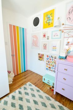 a child's room decorated in pastel colors, with pictures on the wall