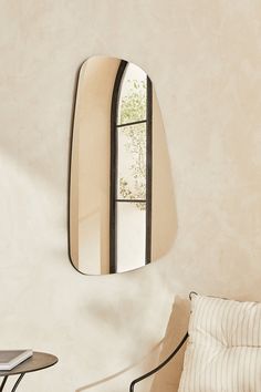 a mirror hanging on the wall next to a bed