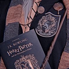 a harry potter book and tie with a badge on it
