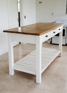 a white kitchen island with wooden top and drawers