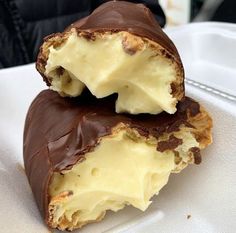 two pieces of chocolate covered dessert sitting on top of a white plate