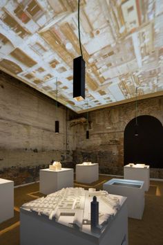 a room filled with lots of white cubes and lights hanging from the ceiling over them