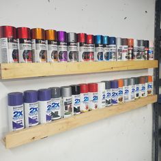 several cans of spray paint on wooden shelves