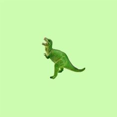 a small green dinosaur jumping in the air