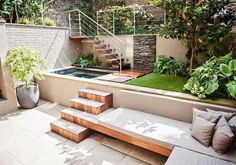 an outdoor living area with stairs, plants and a pool in the middle of it