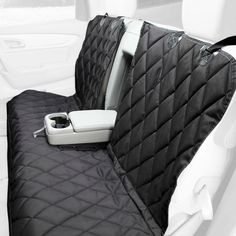 the inside of a car with two back seats covered in black quilting and an electronic device sitting on top of it