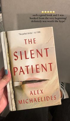 a person holding up a book in their hand with the title, the silent patient