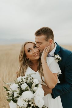 a bride and groom kissing in a wheat field