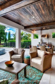 an outdoor living room with chairs and tables in front of a large open patio area