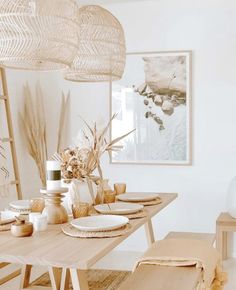 a dining room table with plates, bowls and vases on top of the table