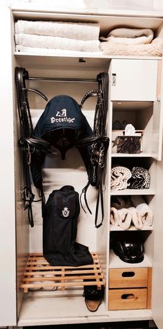 the inside of a white closet filled with shoes and gear, including an umbrella hat