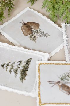 three small trays with pictures of plants on them and gold glitter trimming around the edges