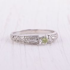 a close up of a ring on a wooden table with a white surface behind it