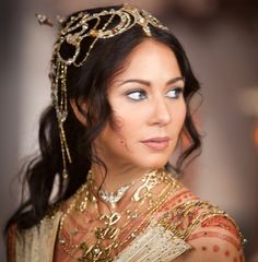 a woman wearing a gold head piece and jewelry