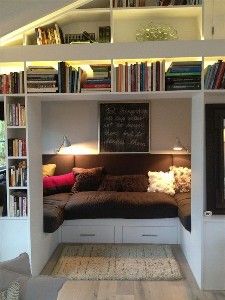 a living room filled with lots of furniture and bookshelves covered in shelves full of books