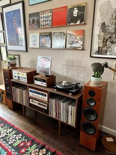 there is a record player on the shelf in this living room with many pictures above it