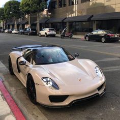 a white sports car is parked on the side of the street