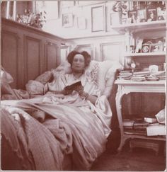 an old black and white photo of a woman in bed