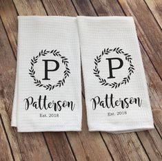two personalized towels on a wooden floor with the word p in black and white