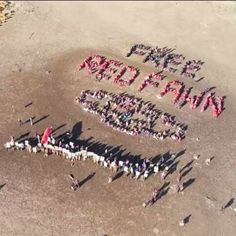 a group of people standing in front of the words happy new year written on sand