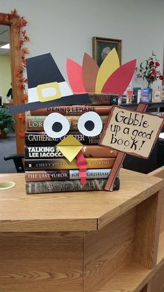 a stack of books sitting on top of a wooden table next to a turkey sign