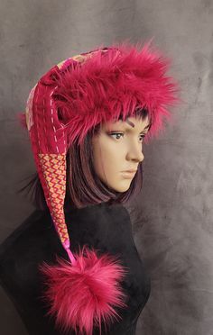 a mannequin head wearing a pink hat with feathers