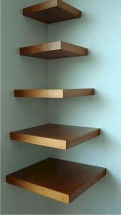 three wooden shelves in a room with blue walls