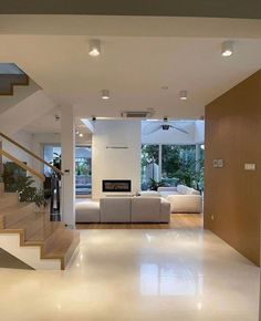 an open living room with stairs leading up to the second floor and a fireplace in the middle