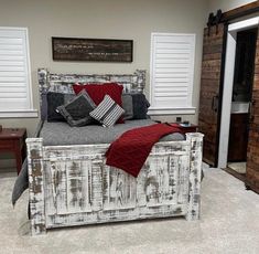 a large bed sitting inside of a bedroom on top of carpeted floor next to a wooden door