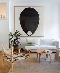 a living room filled with furniture and a painting on the wall