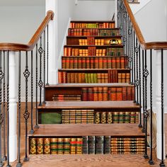 the stairs are lined with books and there is also a set of handrails