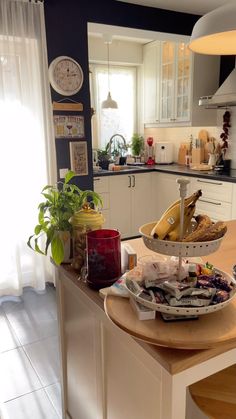 the kitchen counter is covered with food and has two baskets on it, along with other items