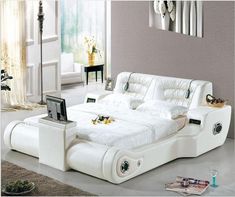 a white bed sitting in the middle of a room