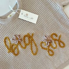 a sweater with gold sequins and bows on it