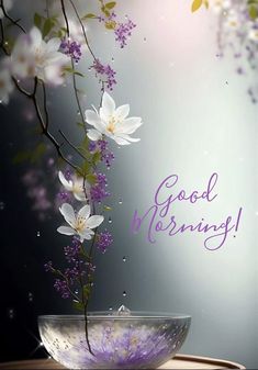 a bowl filled with flowers on top of a wooden table next to a sign that says good morning