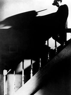 black and white photograph of a woman sitting on the stairs with her back to the camera