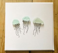 three jellyfishs sitting on top of a piece of paper