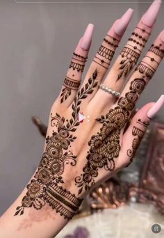 a woman's hand with henna tattoos on it