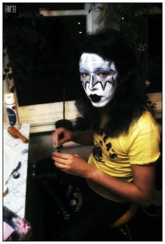 a man with his face painted like a clown sitting in front of a computer desk