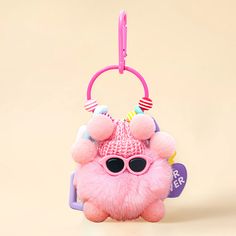 a pink stuffed animal with sunglasses on it's head and a keychain