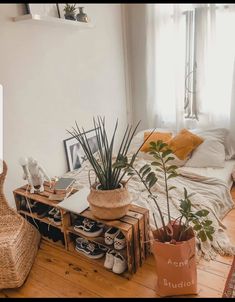 a bed room with a neatly made bed next to a plant and shoes on the floor