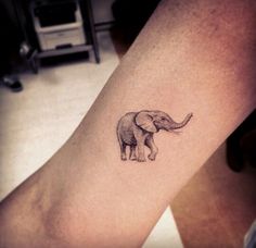 an elephant tattoo on the leg of a woman's right arm, which is showing its tusks