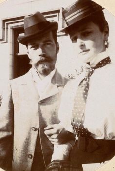 an old black and white photo of a man and woman wearing hats, ties and jackets