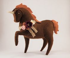 a stuffed horse with flowers on it's back legs is shown in front of a white background